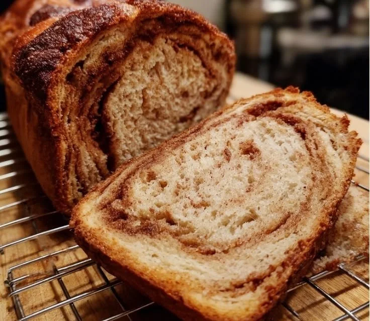 Freshly baked cinnamon sourdough bread with a golden crust and spiral filling.