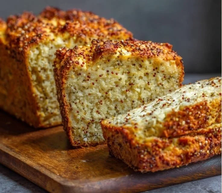 Loaf of cottage cheese quinoa bread sliced on a wooden cutting board