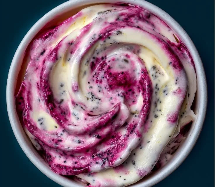 Creamy homemade frozen yogurt with a berry swirl in a colorful bowl
