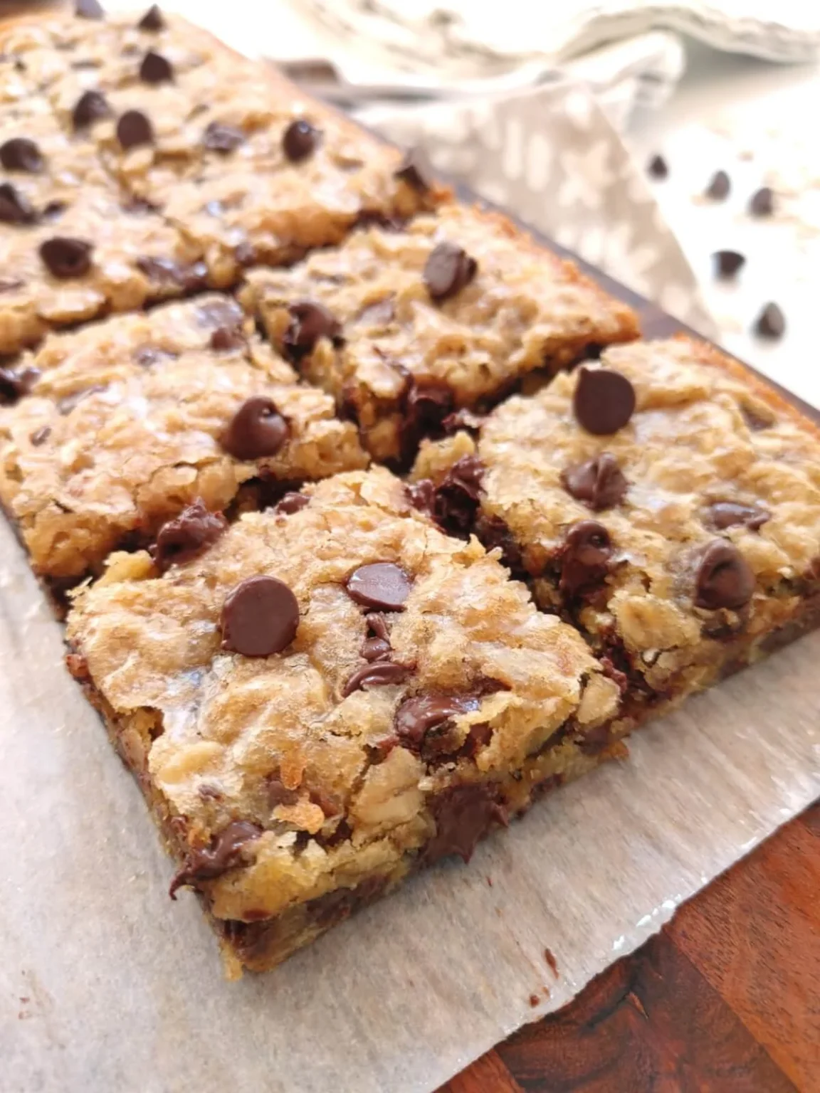 Old-fashioned oatmeal chocolate chip cookie bars on a wooden table